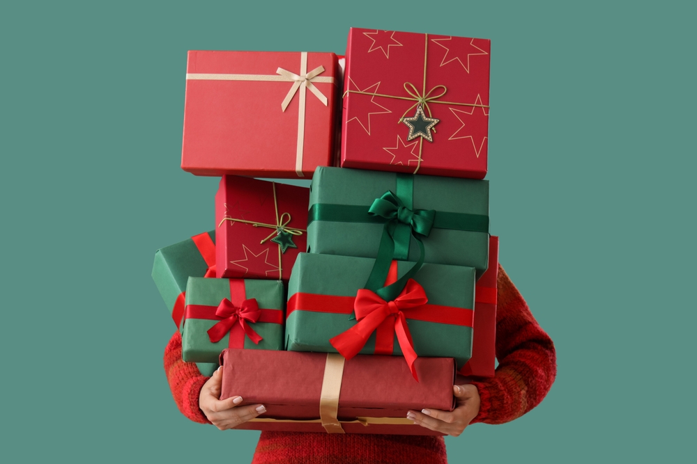 Woman,Holding,Stack,Of,Different,Christmas,Gifts,On,Color,Background